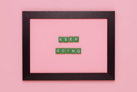 A framed motivational quote on a pink background for inspiration.